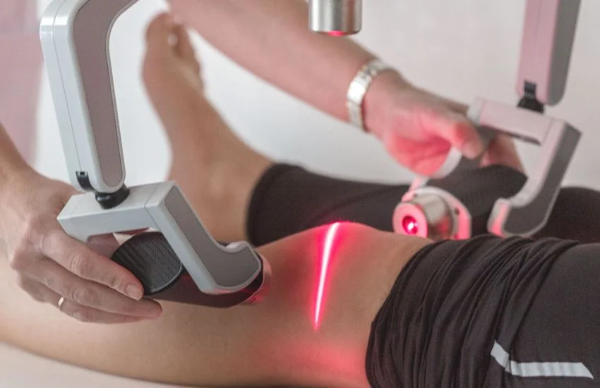 Aplicación de terapia láser en la rodilla para tratar lesiones musculares y articulares sin cirugía